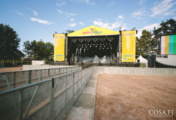 Festivaalien esiintymislava ja sen edessä alumiinista barrikadi-aitaa (paineaita)