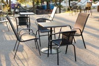 Mustia tuoleja ja pöytiä auringonlaskussa festivaalien VIP-alueella