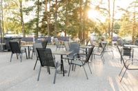 Mustia tuoleja ja pöytiä auringonlaskussa kesätapahtumassa