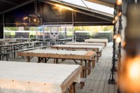 Kesäyö Tuska Festivaalin ruokateltassa feasterien rakennusvaiheessa Rustiikkisia PP-settejä Tuska Festivaalin ruokateltassa