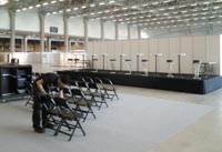 Esiintymislava, mustia Jenkki-taittotuoleja, baarijakkaroita ja pystypöytiä esiintymislavalla