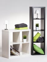 Kaksi erikokoista Block-hyllykköä, somistetyynyjä ja -vilttejä sekä vuokravalaisimia ja tekoviherkasveja esimerkinomaisessa studiokuvassa