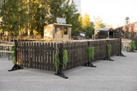 Mustaa Picket puuaitaa viherkasvisomistein ulkona Helsingin Suvilahdessa