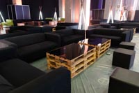 Tummia sohvia ja raheja sekä Pallet-kuormalavapöytiä messujen rakennusvaiheessa Tummia sohvia ja raheja sekä Pallet-kuormalavapöytiä messujen rakennusvaiheessa