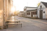 Penkkipöytäsettejä kesäisessä auringonlaskussa Tuska Festivaaleilla Helsingin Suvilahdessa