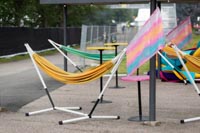 Riippumattoja ja eri korkuisia pystypöytiä festivaalialueella