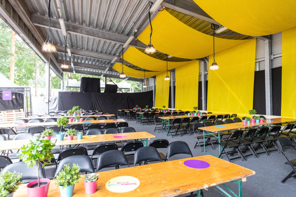Tikkurila Festivaalien VIP-alueen yhden ruokakatoksen keltaisia suuria kangassomistuksia sekä pöytien kevytsomisteita