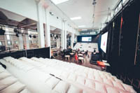 Kaksiosainen valkoinen katsomo valkoisilla istuintyynyillä Helsingin Kattilahallissa Kaksiosainen valkoinen katsomo valkoisilla istuintyynyillä Helsingin Kattilahallissa