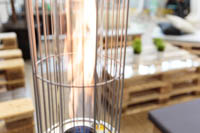 Lähikuva kaasulämmittimen näkyvästä elävästä liekistä suojaritilän takana