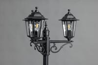 Kolme valaisinta mustassa katulampussa, valot ovat pois päältä