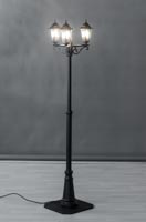 Kolmipaikkainen musta lyhtypylväs missä valot päällä