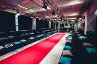 Muotinäytöksen maantasainen punaisella matolla toteutettu catwalk ja nousevat katsomot