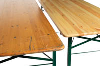 Lähikuvassa kaksi eri kuntoista puista suorakaidepöytää vierekkäin