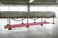 Messinkisiä Gala kulunohjaimia punaisella köydellä kahdelle puolelle punaista mattoa aseteltuna