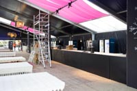 Mustalla levyllä levytetty myyntitiski festivaalien rakennusvaiheessa valokuvattuna