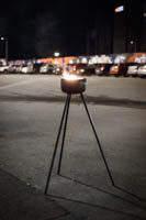 Ulkotuli palaa telineessä asvalttikentällä pimeässä syysillassa